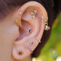 an ear with several different types of piercings on the top and bottom of it