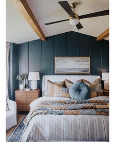 a large bed sitting under a ceiling fan next to a painting on the wall in a bedroom