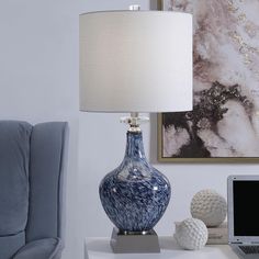 a blue and white vase sitting on top of a table next to a laptop computer