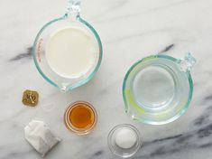 ingredients to make an iced drink sitting on a marble counter top, including milk and sugar