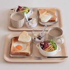 two trays filled with food on top of a table