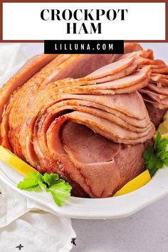 ham sliced on a plate with lemon wedges and parsley