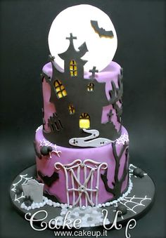 a three tiered cake decorated in purple and black with a spooky graveyard scene