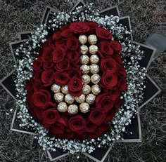 a bouquet of red roses and chocolates with the letter d spelled out in it