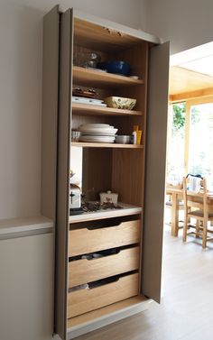 an open cabinet with dishes and bowls on it