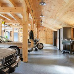 a garage with two motorcycles and cars parked in the space next to eachother