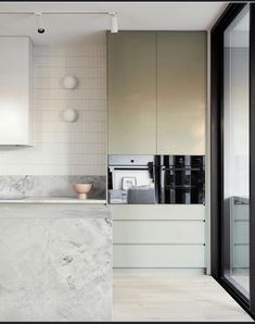 a kitchen with marble counter tops and white cabinets