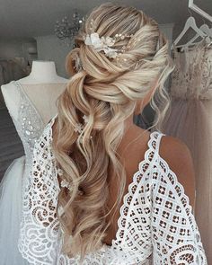 the back of a woman's head with long hair in a half - up braid