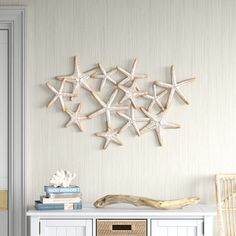 five starfishs are mounted on the wall above a white cabinet in a room