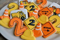 decorated cookies with road signs and traffic cones on a white plate, ready to be eaten