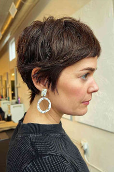 Thick brunette pixie cut with mini bangs, a modern twist on a 90s classic. Pixie Haircut Celebrities, Pixie Short Bangs Haircut, Pixie Haircut Women In 40s, Long Fringe Pixie Haircut, Very Thick Short Hair, Chic Short Haircuts For Thick Hair, Back Of A Pixie Haircut, Long Pixie Updo, "shixie" Haircut