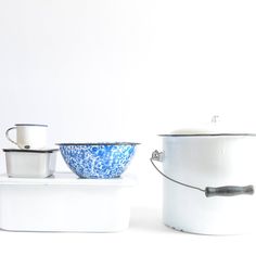 two white and blue pots sitting on top of a counter next to each other with lids