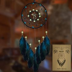 an image of a dream catcher with beads and feathers hanging from it's side