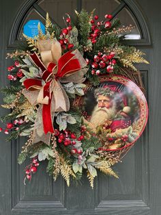 a christmas wreath on the front door of a house with santa claus and holly berries