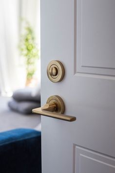 an open door with two knobs on it and a blue ottoman in the background