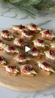 a wooden platter filled with cranberry and cheese appetizers