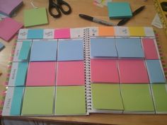 several different colored sticky notes on a table with scissors and other office supplies around them