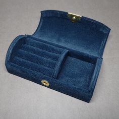 a blue velvet case with two compartments on the front and one compartment in the back