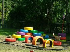 a pile of colorful tires sitting on top of a grass covered field