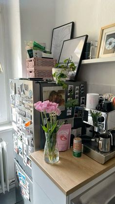 a kitchen counter with flowers and pictures on the wall