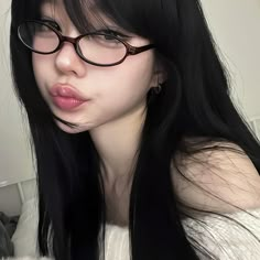 a woman with long black hair wearing glasses