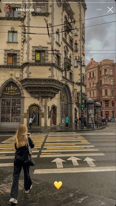 a woman standing in the middle of a street with an orange heart hanging from it's side