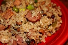 a red plate topped with rice and sausage