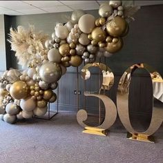 a large balloon arch is decorated with gold and silver balloons for the 50th anniversary celebration