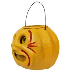 a yellow pumpkin with a face painted on it's side and eyes drawn to look like a cat