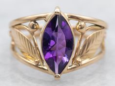 This pretty vintage amethyst ring has a lovely purple amethyst in the center, that really flashes and flickers with vibrant violet reflections! Set into a lovely vintage mounting with engraved leaf shoulders and simple prongs, this vintage ring is a beautiful addition to anyone's collection! Metal: 14K Yellow Gold Gem: Amethyst .87 Carats Gem Measurements: 5.4 x 10.3 mm, Marquise Cut Ring Size: 5.25 Marks: "14K" Stamped on the inside band SKU #: A27208 Each piece has been identified and graded b Vintage Amethyst Ring, Amethyst Ring Vintage, Marquise Cut Rings, Watch Chain, Yellow Gold Ring, Vintage Ring, Marquise Cut, Ring Vintage, Amethyst Ring