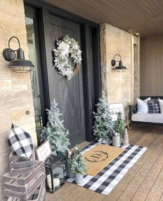 the front porch is decorated for christmas with wreaths and potted trees on it