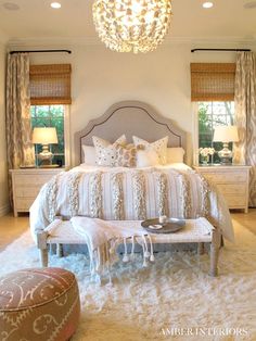 a bedroom with white bedding and chandelier