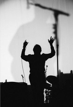 a man standing in front of a microphone with his hands up