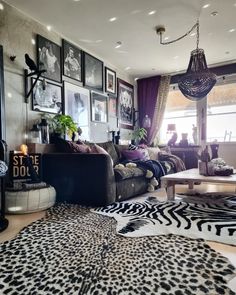 a living room filled with lots of furniture and pictures on the wall next to a window