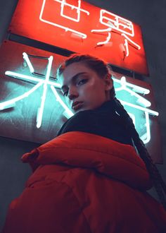 a woman standing in front of a neon sign