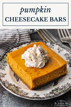 a slice of pumpkin cheesecake bars on a plate with whipped cream in the middle