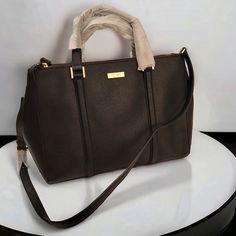 Kate Spade Large Loden Newberry Lane Satchel In Black Saffino Leather. Features Light Gold Hardware,Logo Placard At Front, Dual Flat Handles Along With A Removable Long Strap. Three Sections Total, Including A Spacious Main Central Compartment With Magnetic Snap Closure And Large Zippered Compartments On Either Side. Expandable Sides With Press Stud Fastening, 1 Interior Zip Pocket & 2 Slip Pockets With Custom Woven Fabric Lining. Approx Measurements 14"10"5" Handle Drop 4.5" Shoulder Strap Is A Luxury Kate Spade Bag With Handles, Hardware Logo, Feature Light, Press Studs, Gold Hardware, Snap Closure, Woven Fabric, Zip Pockets, Kate Spade