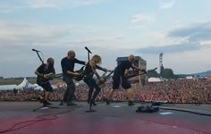 a group of people standing on top of a stage with guitars in front of them