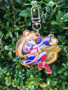 a keychain with a cartoon character on it hanging from a green tree filled with leaves