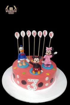 a birthday cake with mickey and minnie mouse on it