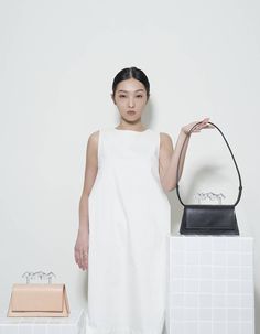 This mono-colour leather bag is accentuated by the 3D-printed handle with its unique silhouette. Structural bag remains subtle on its exterior, while becomes fulfilling with the brass details and card pocket within.- 3D-printed top handle- vegetable-tanned leather bag with card pocket- gold-plated brass componenets- adjustable stripe for side or crossbody look- handcrafted handbag- bag Size: 23cm (L.) x 10cm (H.) x 8cm (D.)- handle Size: 13cm (L.) x 2.5cm (W.)Delivered with hand-sewn pouches. Bl Minimalist Structured Shoulder Bag With Detachable Handle, Minimalist Shoulder Bag With Top Handle And Leather Handles, Minimalist Structured Bags With Top Carry Handle, Minimalist Structured Bag With Top Carry Handle, Minimalist Structured Bag With Detachable Strap, Minimalist Structured Shoulder Bag, Minimalist Structured Bag With Removable Pouch, Minimalist Structured Bags With Removable Pouch, Tan Leather Handbags