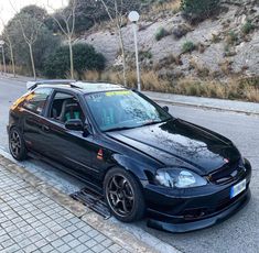 a black car is parked on the side of the road