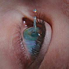 a close up view of the inside of a persons eye with water drops on it