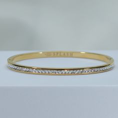 fire up a playful conversation on a sparkling night in our Enchanted Bangle Bracelet. double stack these babies for a luxurious vibe. a timeless staple that will be by your side for every special moment. channel set cz's add just the right amount of sparkle to light up the night. simply add a glass of champagne and you're ready for any celebration. 18kt gold or rhodium pvd over 316L stainless steel water resistant channel set cz's 4mm thick inside diameter is 2.5" pressure click closure sold ind Luxury Metal Bracelet With Sparkling Stones, Luxury Metal Bracelets With Sparkling Stones, Sparkling Dazzling Bracelets For Gifts, Sparkling Bracelets For Gifts, Adjustable Bling Bangle Bracelet, Dazzling Adjustable Bangle Bracelet, Stackable Cubic Zirconia Bracelets For Party, Elegant Stainless Steel Bracelets With Bling, Elegant Stainless Steel Bling Bracelets