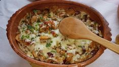 a wooden spoon in a pot filled with food