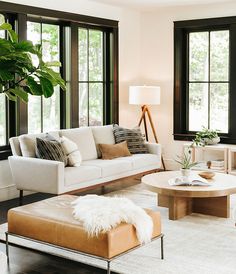 a living room filled with furniture and large windows