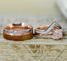 two wedding rings with one diamond and the other in rose gold, on top of a piece of wood