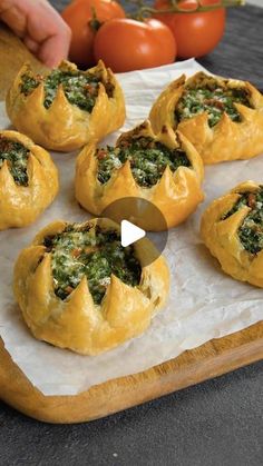 a wooden cutting board topped with bread covered in spinach