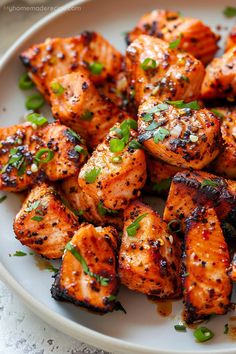 a white plate topped with grilled chicken and garnished with parsley on top