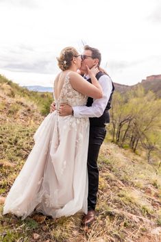 a bride and groom kissing in the desert